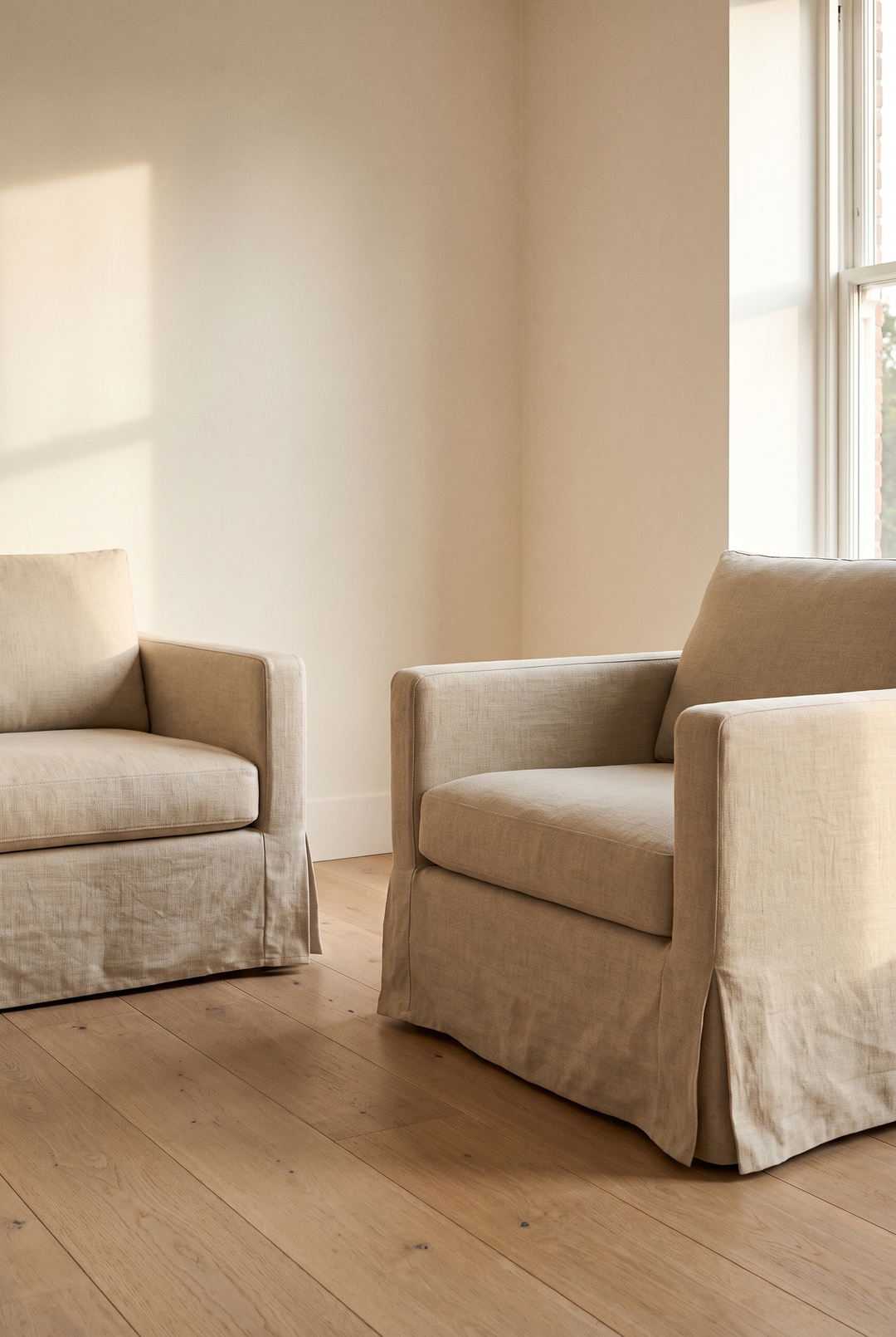 An armchair dressed in a fitted oat slipcover