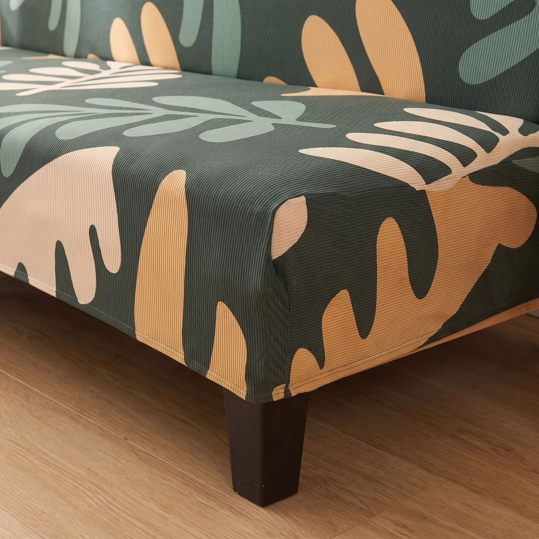 Stretch Futon Cover – Armless in Dark Green – Abstract Leaf – close-up of the seat edge and dark wooden leg on a hardwood floor