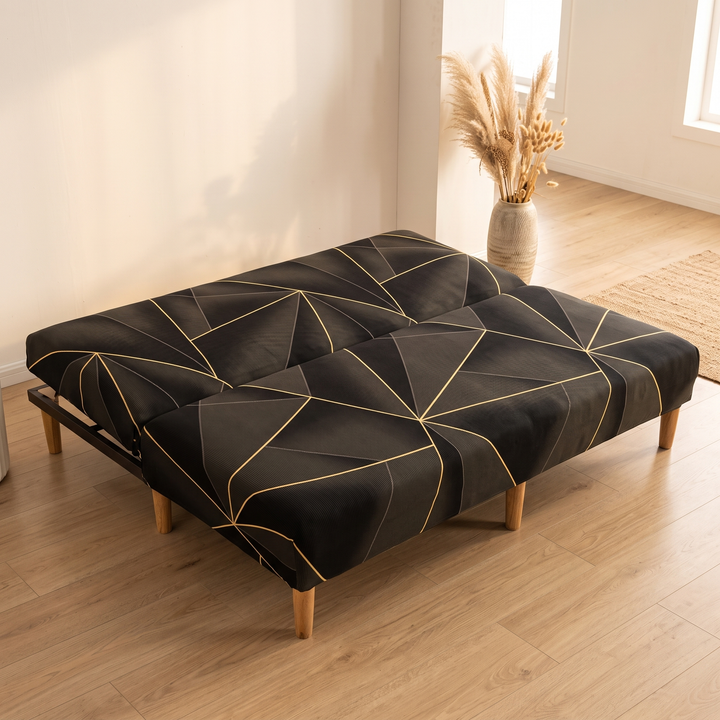 Stretch Futon Cover – Armless in Black – Golden Line – reclined flat beside a vase of dried grasses and jute rug corner