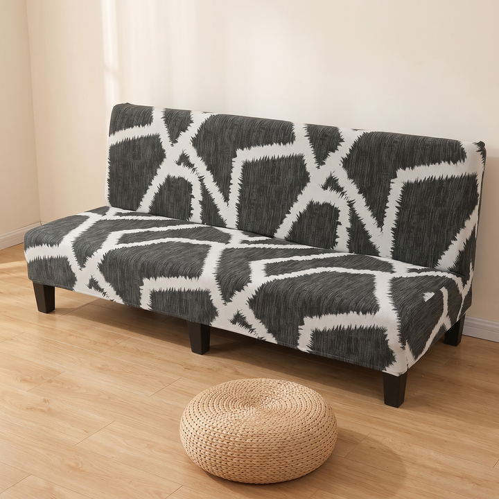Stretch Futon Cover – Armless in Charcoal – Lattice – left-end angle with a woven rattan pouf on the floor