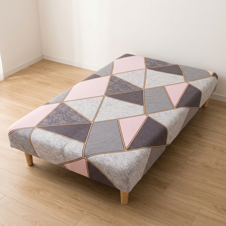 Stretch Futon Cover – Armless in Light Pink – Geometric – tucked into a corner where two white walls meet