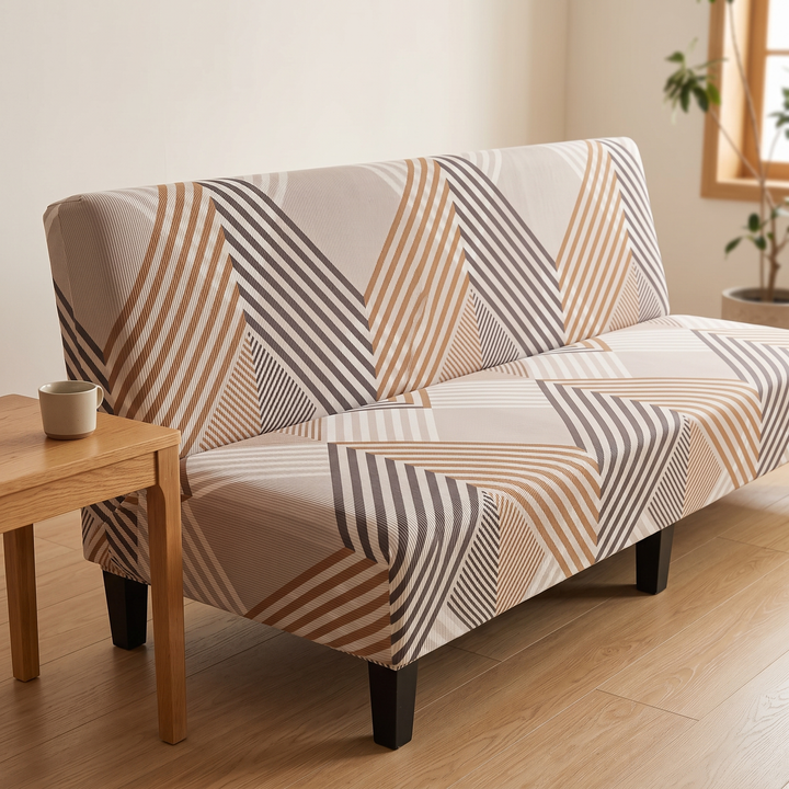 Stretch Futon Cover – Armless in Taupe – Chevron Stripe – beside a small wooden side table holding a mug