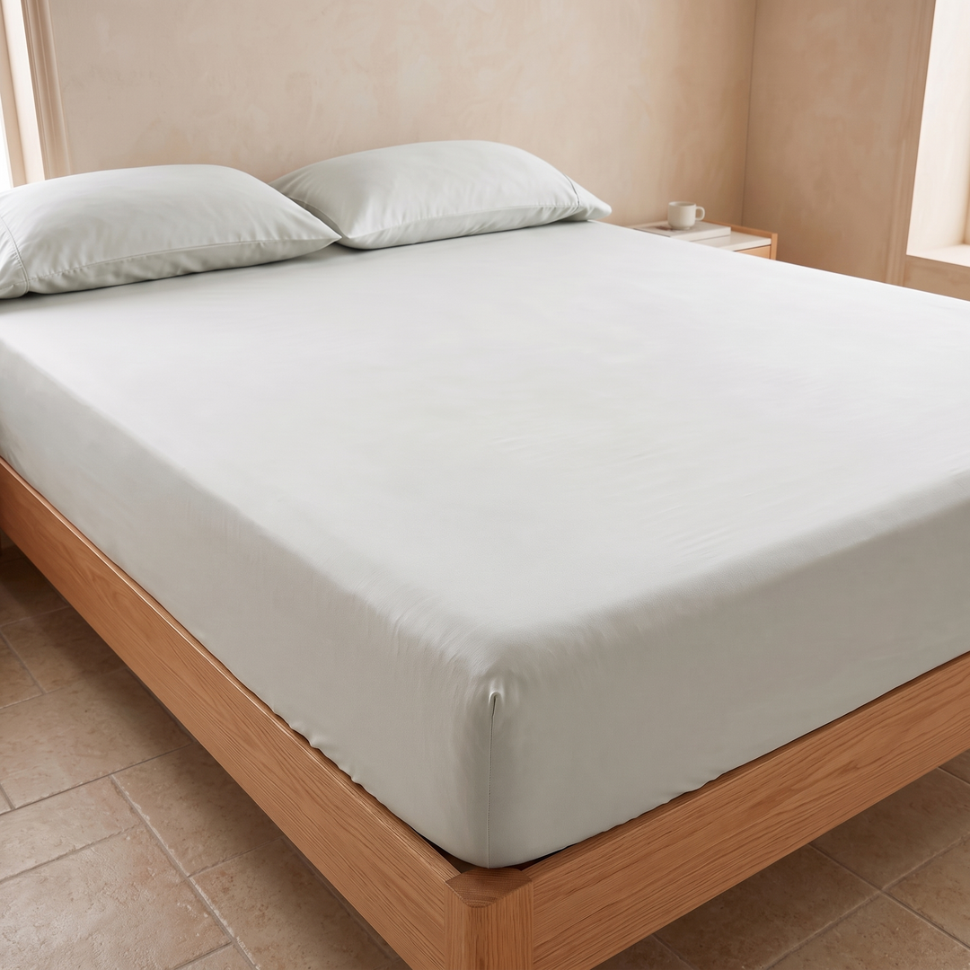 Bamboo Viscose Fitted Sheet Set with Pillowcases in Light Green – angled side view of mattress with pillows above a tile floor