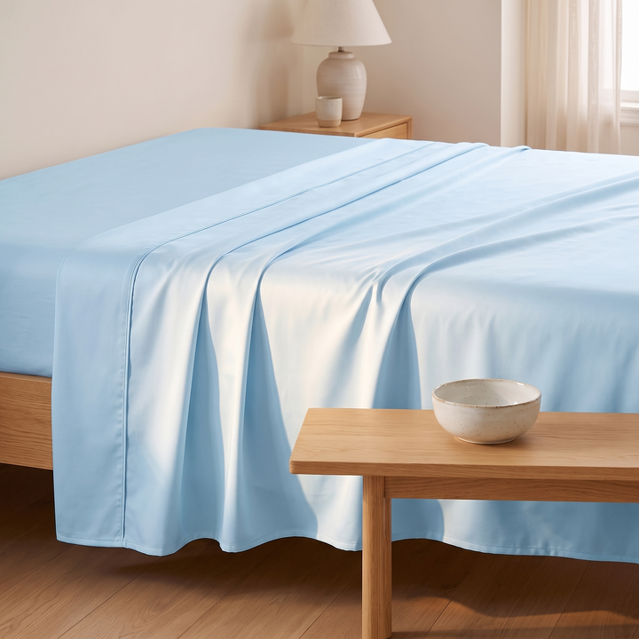 Bamboo Viscose Flat Sheet in Light Blue – side view with a wooden bench and ceramic bowl in foreground