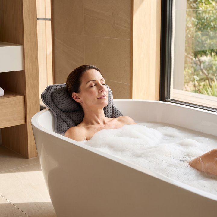 Bath Pillow with Suction Cups in Dark Gray – in use by a woman reclining in a bubble bath