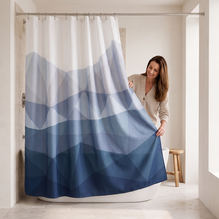 Blue Geometric Fabric Shower Curtain in Blue – woman in cream cardigan holding up the curtain&