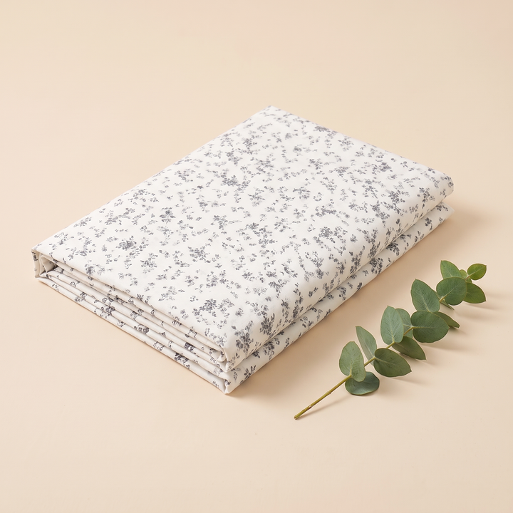 Body Pillowcase – Printed in Gray Floral – with a eucalyptus sprig resting beside the folded fabric