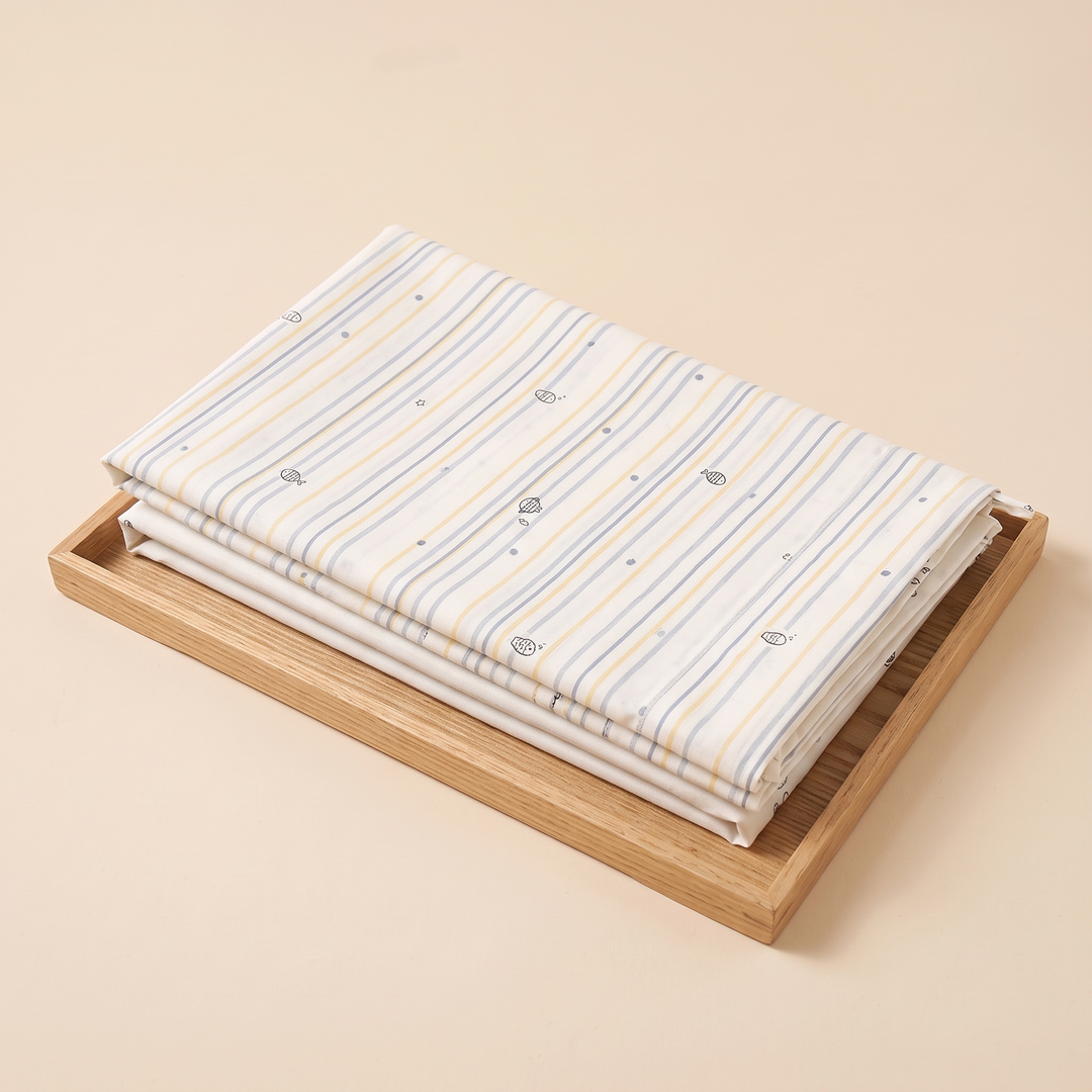 Body Pillowcase – Printed in Pastel Blue Stripe – folded on a light wooden tray against a peach background