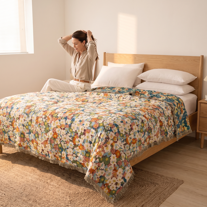 Boho Floral Gauze Bedspread with Fringe in Green Ditsy Floral – covering a bed with a woman tying her hair