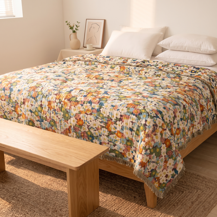 Boho Floral Gauze Bedspread with Fringe in Purple Ditsy Floral – viewed past a wooden bench toward a nightstand