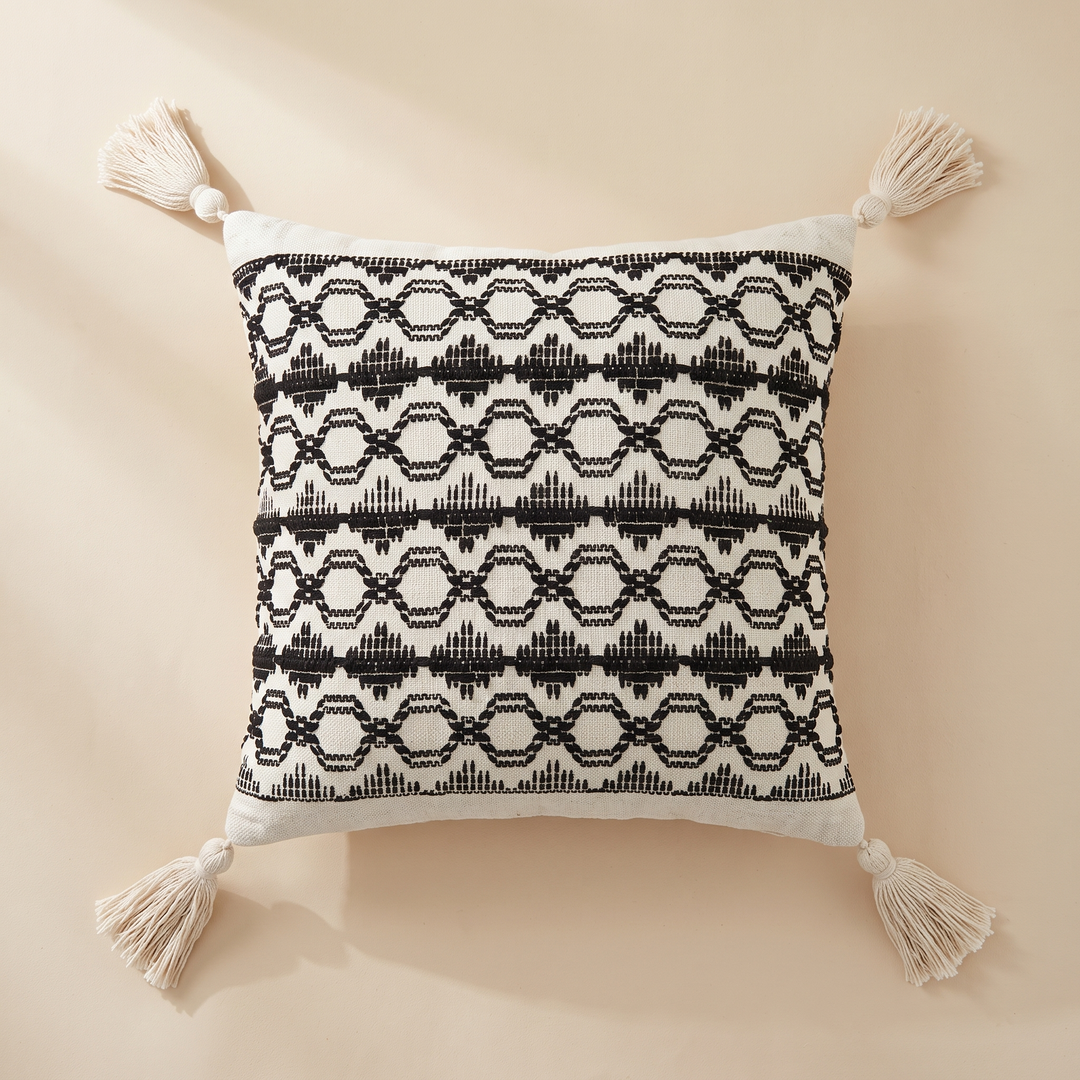 Boho Pillow Cover with Tassels – Woven in Cream – Black Geometric – flat with diagonal sunlight shadow across upper left corner