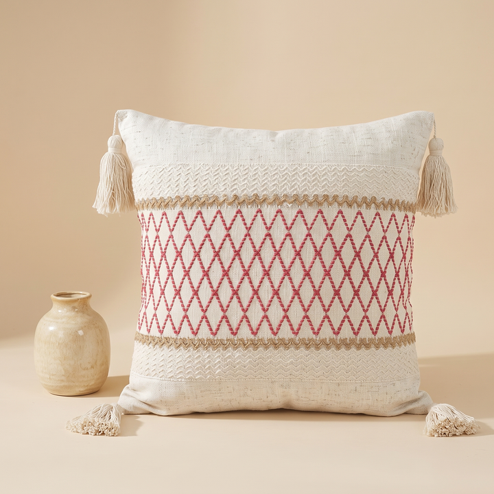 Boho Pillow Cover with Tassels – Woven in Cream – Pink Lattice – upright next to a small round ceramic vase