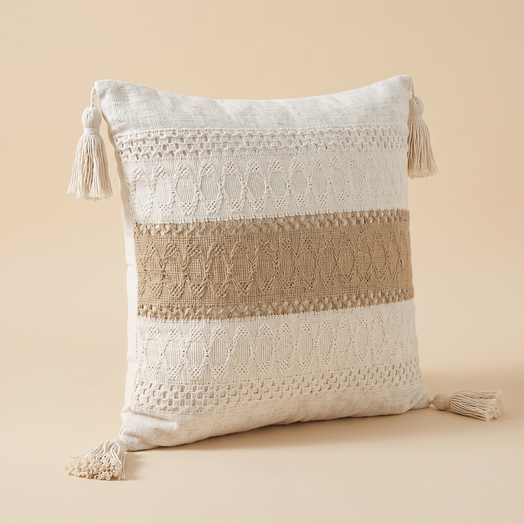 Boho Pillow Cover with Tassels – Woven in Cream – Tan Stripe – angled three-quarter view resting on a seamless studio surface