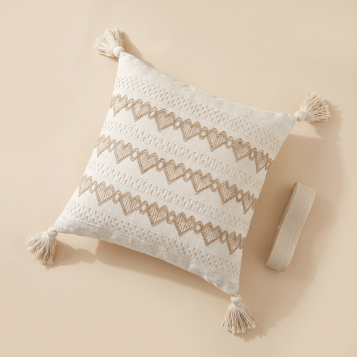 Boho Pillow Cover with Tassels – Woven in Cream – Tan Zigzag – overhead flat lay beside a small roll of woven ribbon
