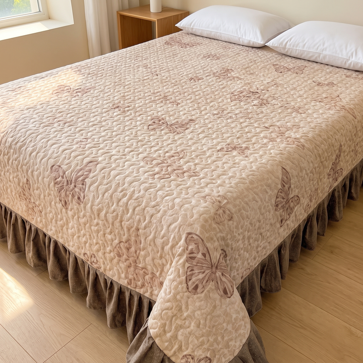 Butterfly Quilt with Ruffled Edge in Beige Butterfly – on a made bed with two white pillows in a sunlit bedroom