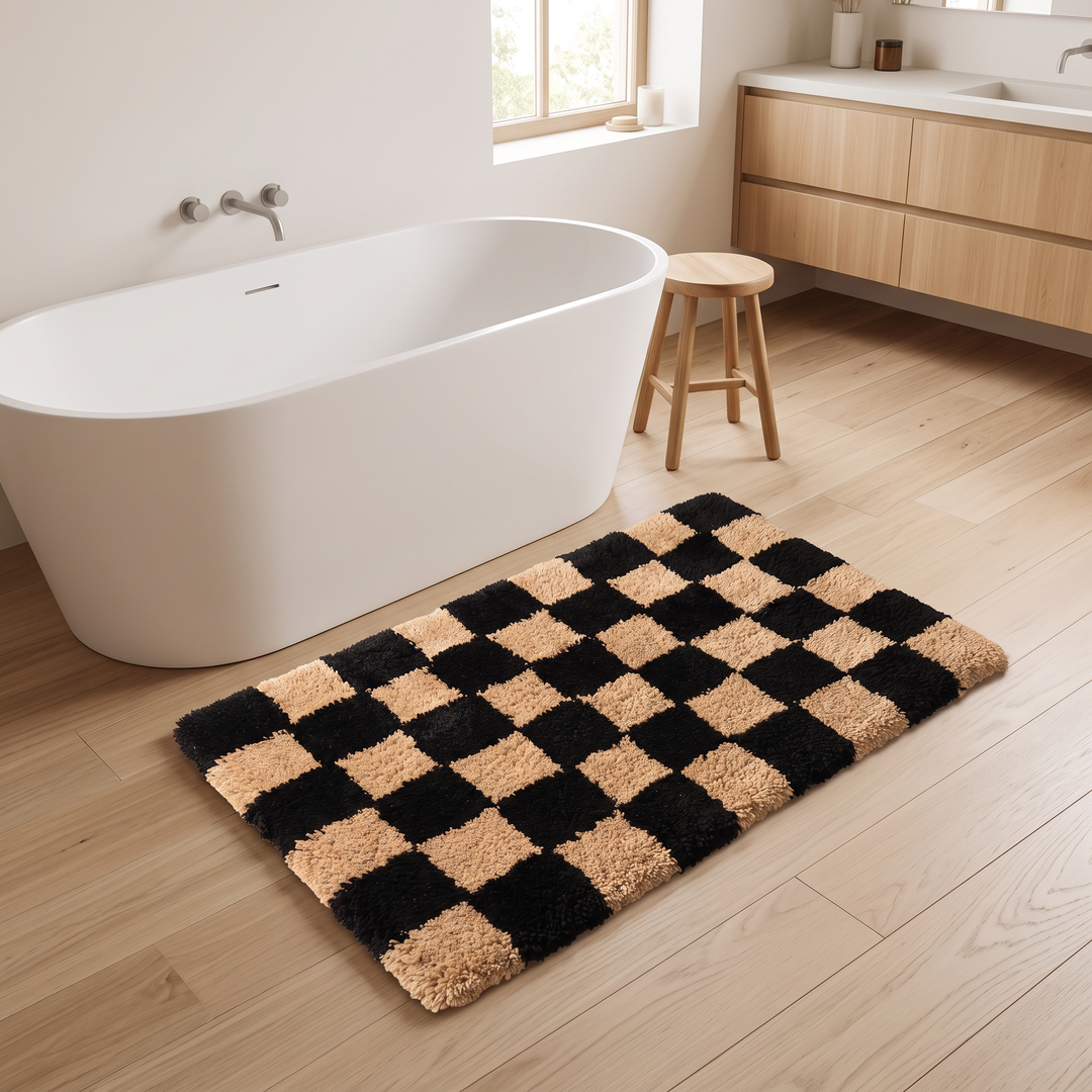 Checkered Bath Rug – Plush, Non-Slip in Black and Tan – on a light wood bathroom floor beside a freestanding tub