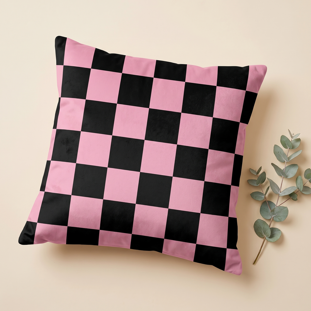 Checkered Pillow Cover in Black &amp; Pink – Large Check – lying flat on a beige surface beside a eucalyptus sprig