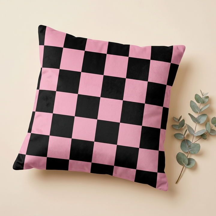 Checkered Pillow Cover in Black &amp; Pink – Large Check – lying flat on a beige surface beside a eucalyptus sprig
