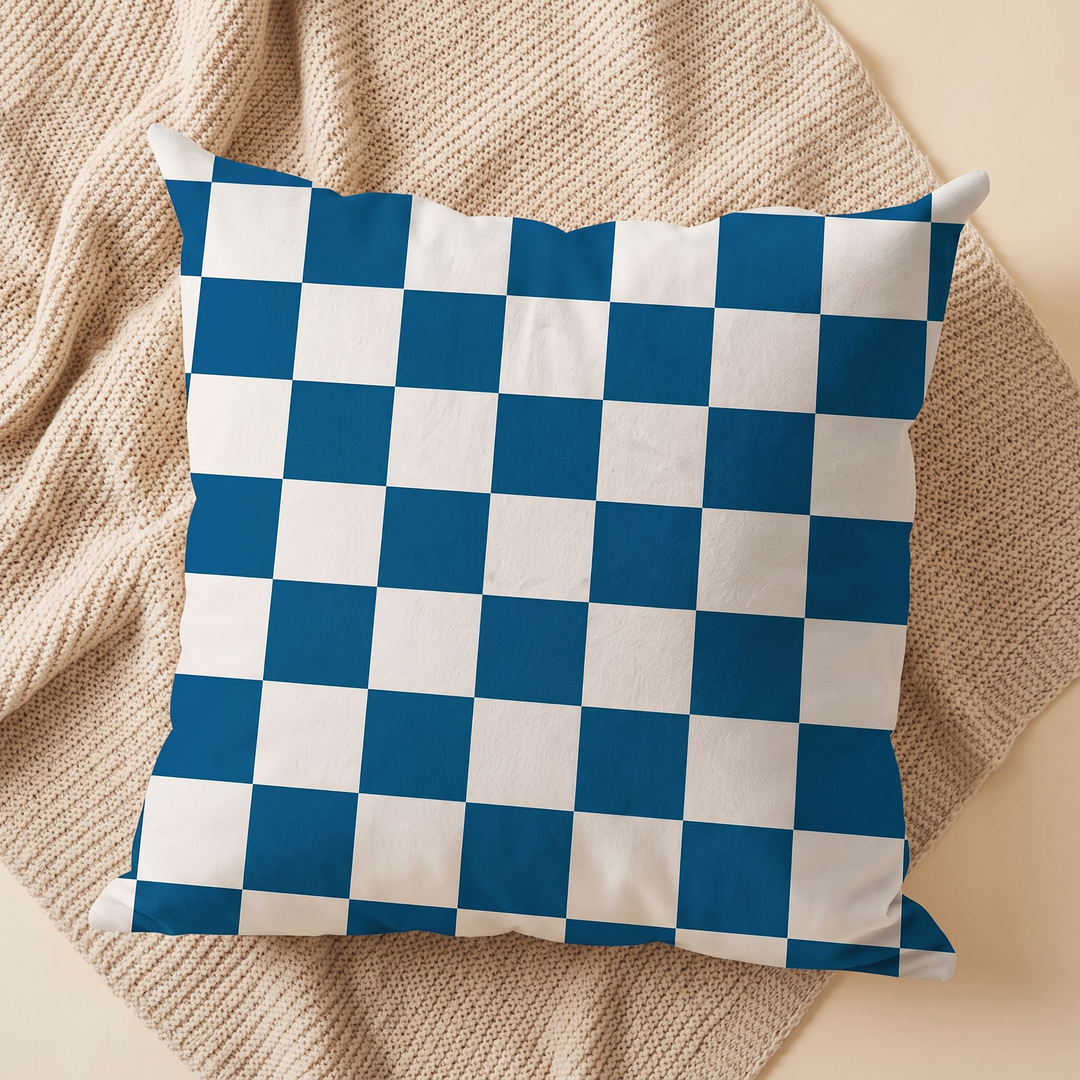 Checkered Pillow Cover in Blue &amp; White Check – centered on a diamond-folded beige knit blanket, overhead view