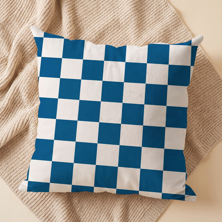Checkered Pillow Cover in Blue &amp; White Check – centered on a diamond-folded beige knit blanket, overhead view