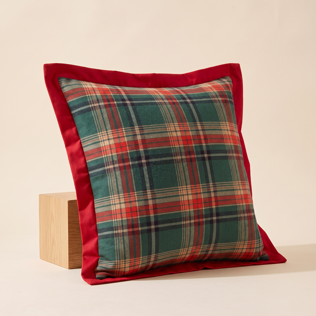 Christmas Plaid Pillow Cover in Green – Bordered Tartan – angled three-quarter view leaning against a wooden block on cream backdrop