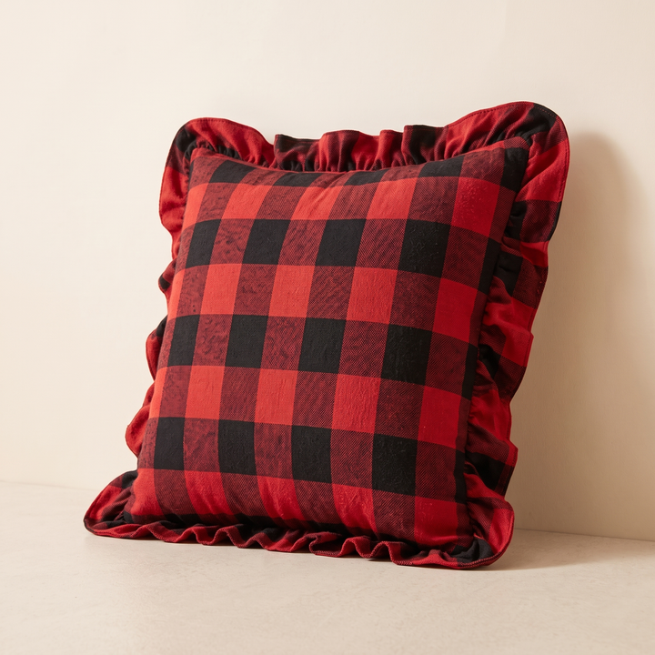Christmas Plaid Pillow Cover in Red – Buffalo Check – leaning against a wall, bottom ruffle resting on floor