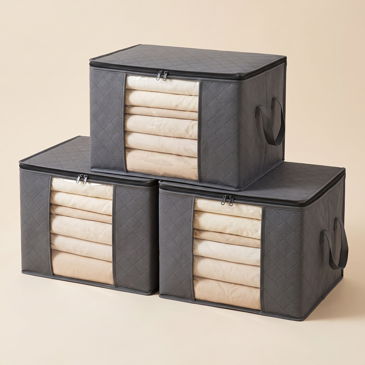 Clothes Storage Bags – Set of 3 in Dark Gray – stacked in a pyramid, filled with folded clothes, on beige