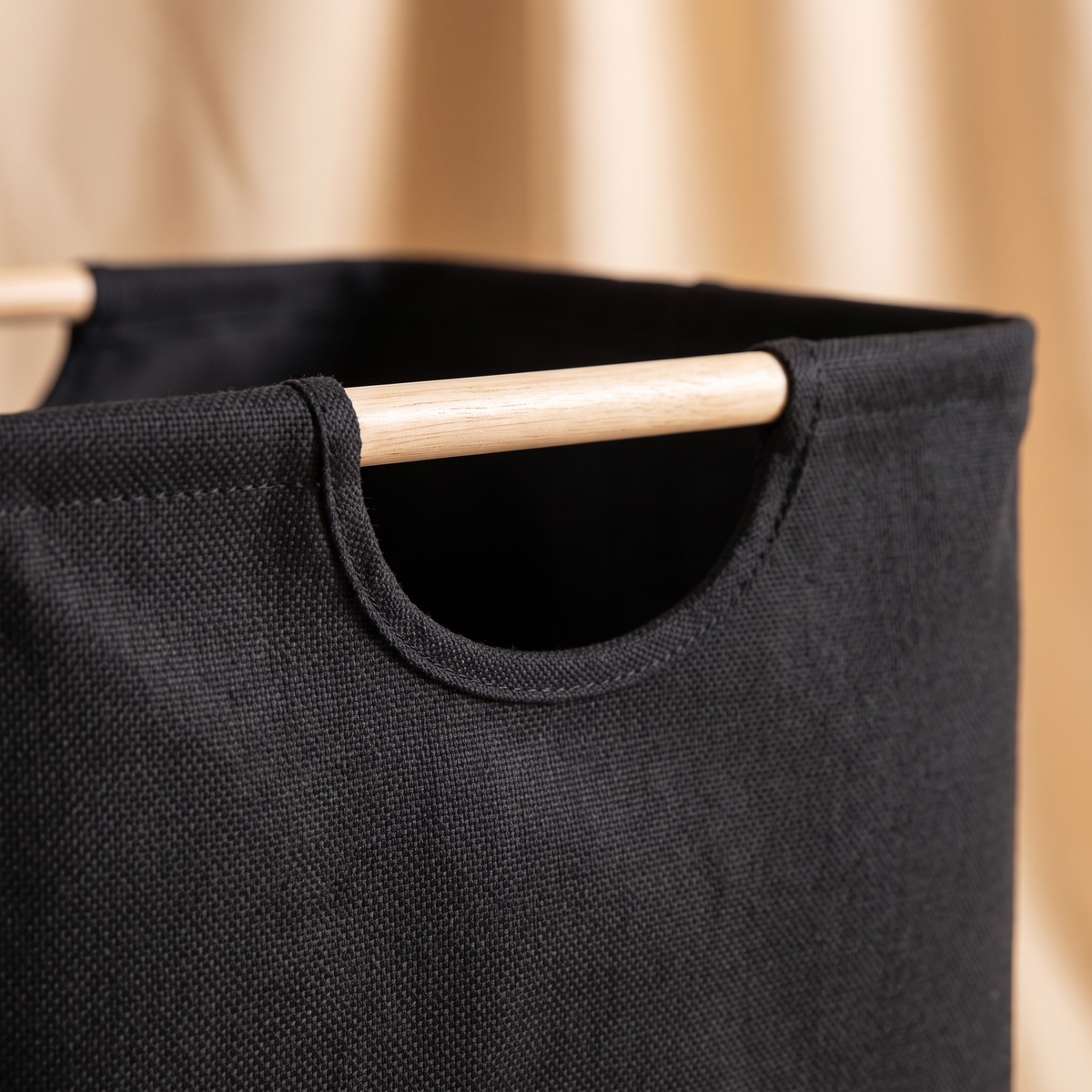 Collapsible Laundry Basket in Black – close-up of the wooden handle and stitched fabric cutout