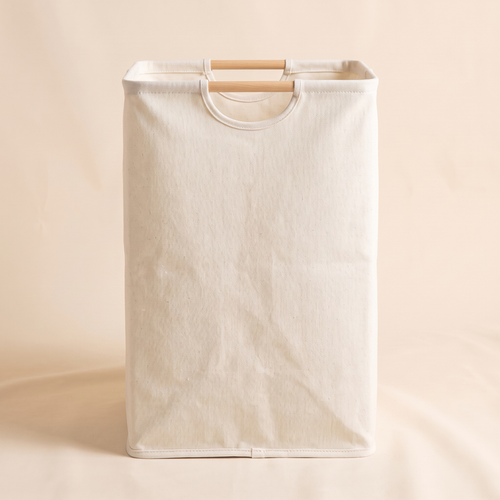 Collapsible Laundry Basket in Cream – straight-on front view showing creased fabric and bottom trim