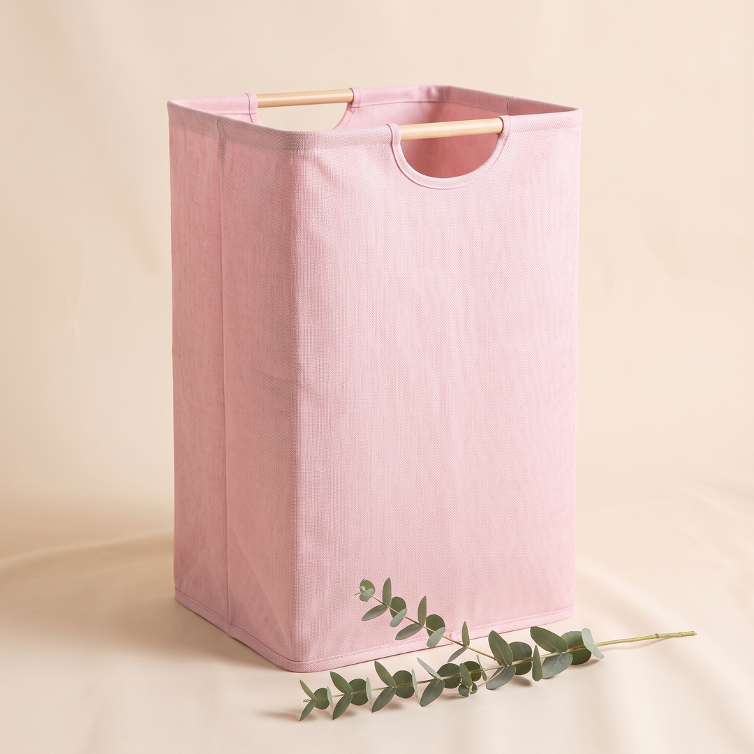 Collapsible Laundry Basket in Light Pink – corner view with a eucalyptus stem lying in the foreground