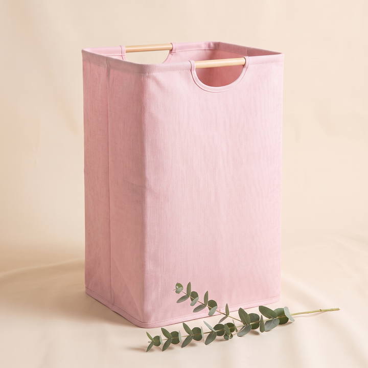 Collapsible Laundry Basket in Light Pink – corner view with a eucalyptus stem lying in the foreground