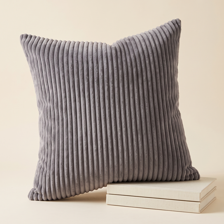 Corduroy Pillow Cover in Charcoal – leaning on a stack of two cream hardcover books