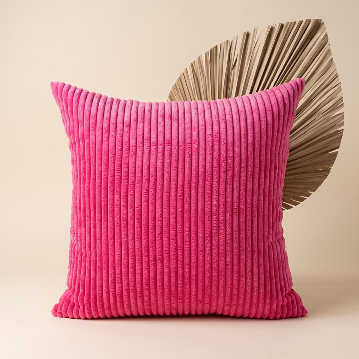 Corduroy Pillow Cover in Hot Pink – upright in front of a dried palm leaf on beige