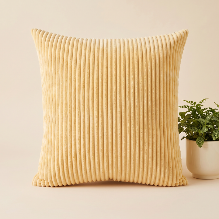 Corduroy Pillow Cover in Light Yellow – upright beside a potted green plant in a white pot