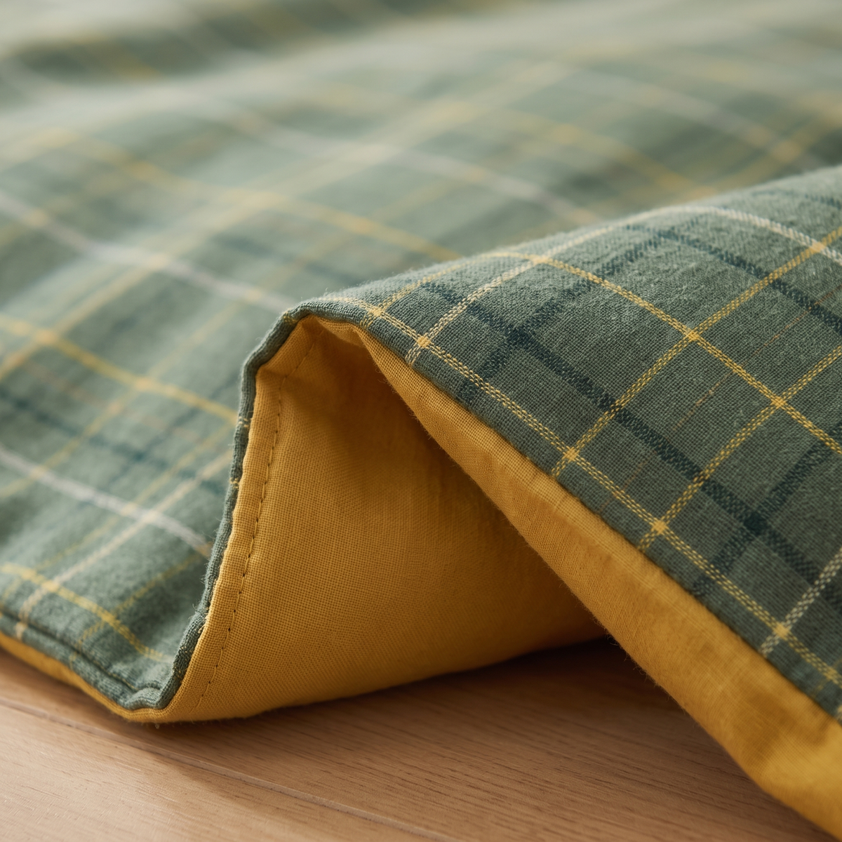 Cotton Duvet Cover Set in Green Plaid – close-up of the stitched edge on a light wood floor
