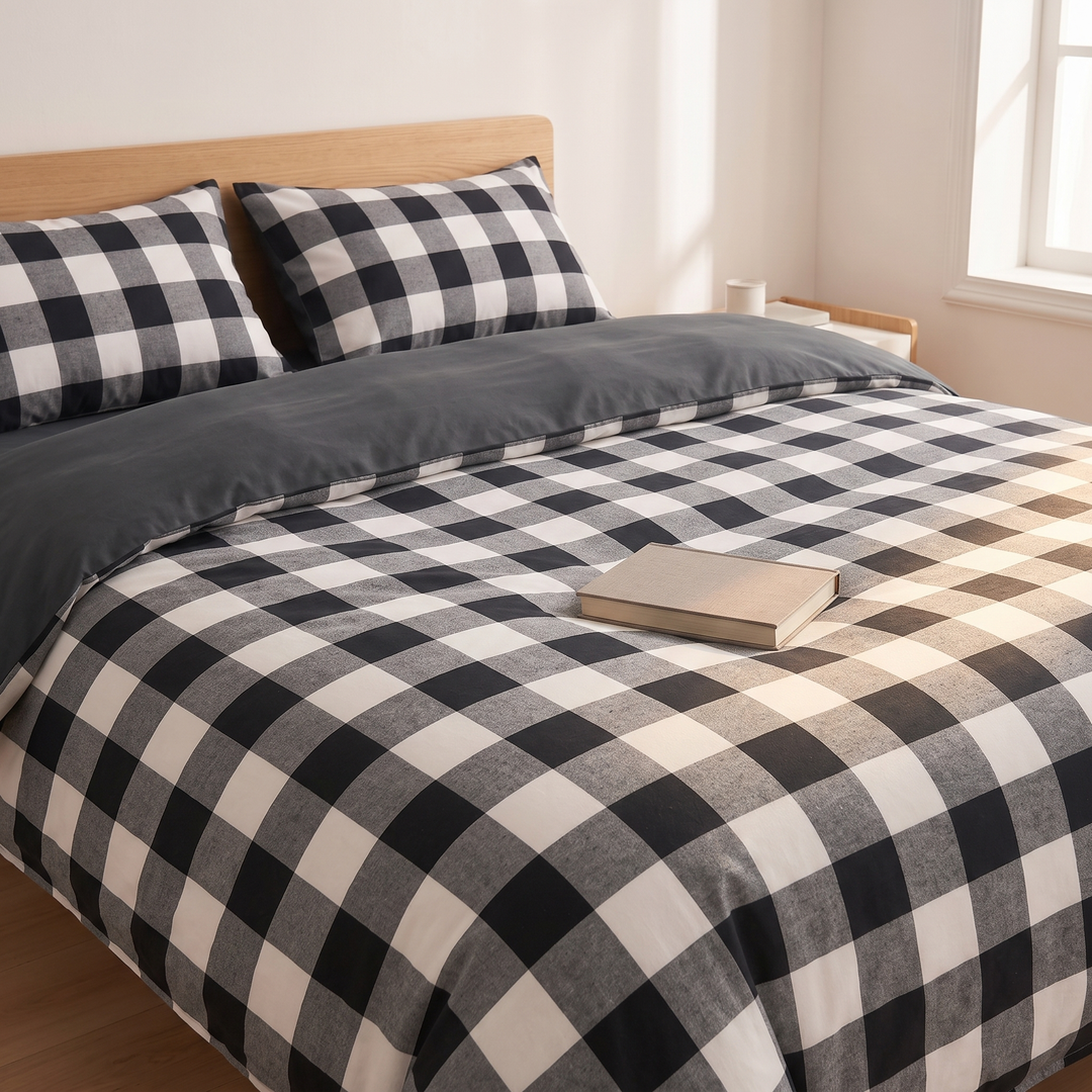 Cotton Duvet Cover Set in Black Buffalo Check – with a closed book resting on top of the bed