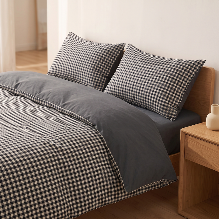 Cotton Duvet Cover Set in Black Gingham – on a bed beside a wooden nightstand with ceramic vase