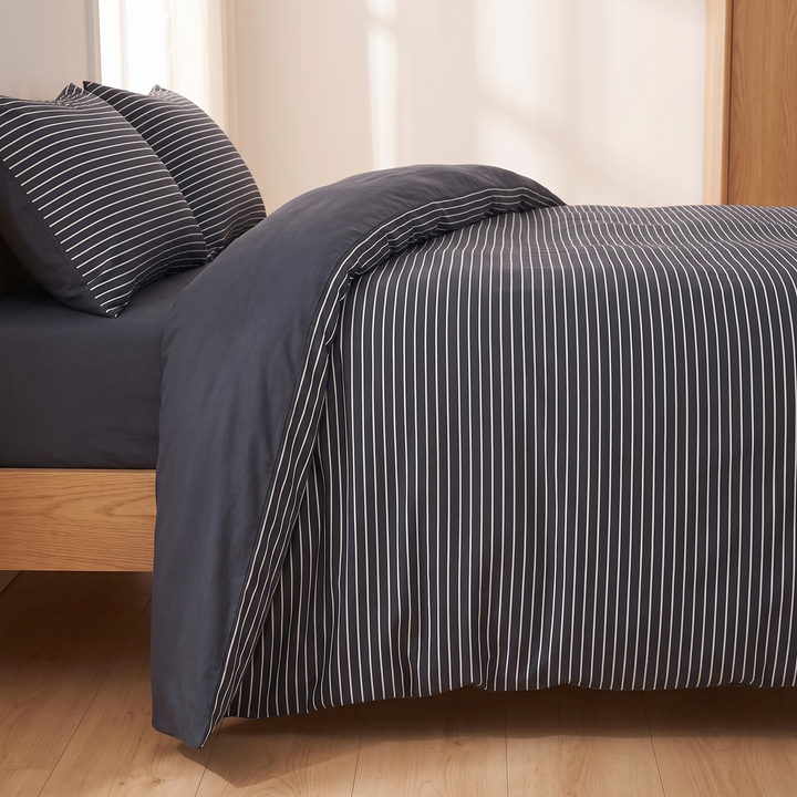Cotton Duvet Cover Set in Navy Stripe – side-on view of oak bed frame with duvet turned back