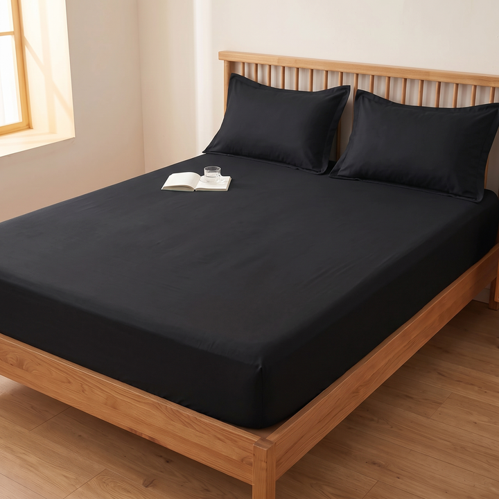Cotton Fitted Sheet Set with 2 Pillowcases in Black – with an open book and glass on the mattress