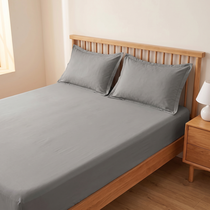 Cotton Fitted Sheet Set with 2 Pillowcases in Gray – angled view with pillows against slatted headboard beside nightstand