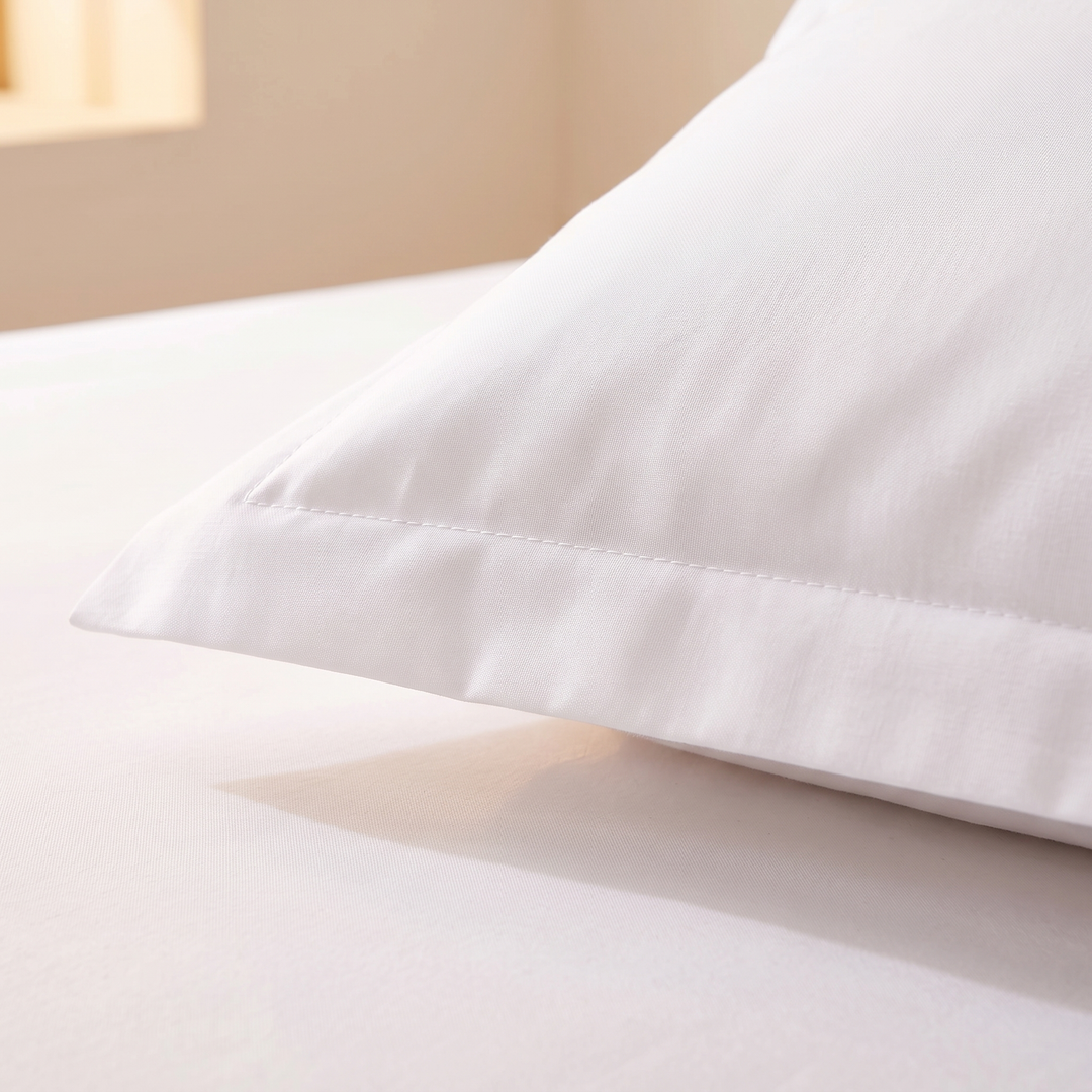 Cotton Fitted Sheet Set with 2 Pillowcases in White – close-up of a pillowcase corner with stitched flange border