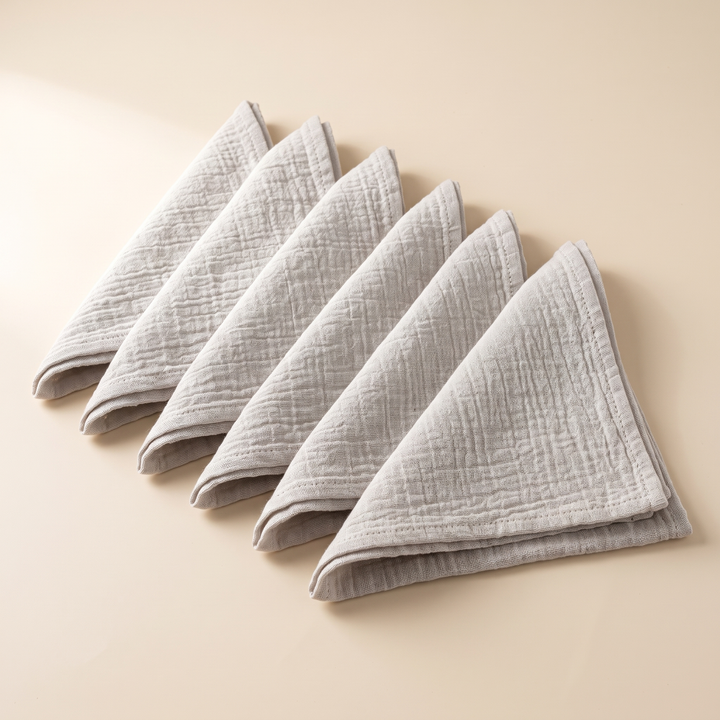 Cotton Gauze Napkins – Set of 6 in Light Gray – triangle-folded napkins lined up side by side, soft shadows