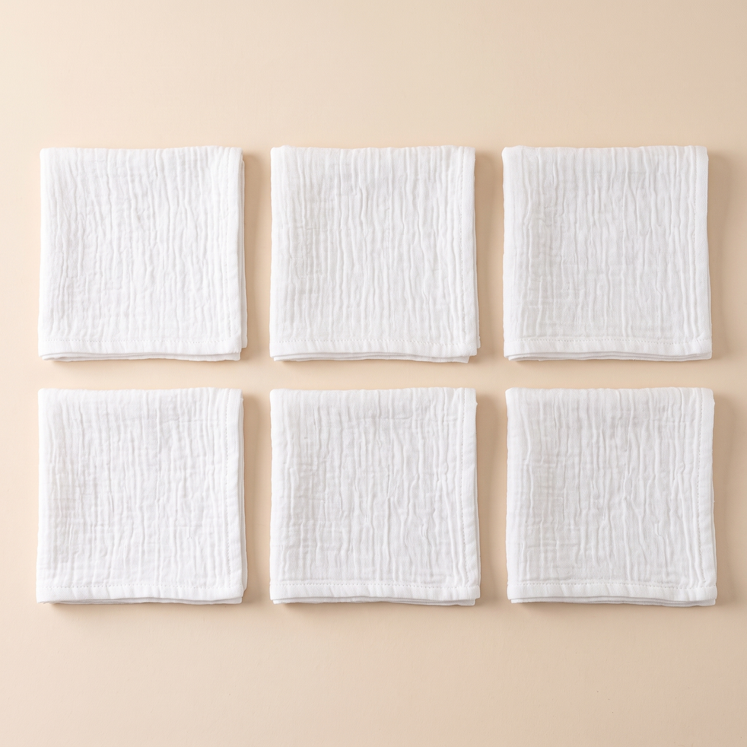 Cotton Gauze Napkins – Set of 6 in White – six folded napkins arranged in two rows on peach
