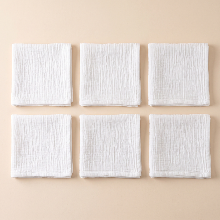 Cotton Gauze Napkins – Set of 6 in White – six folded napkins arranged in two rows on peach