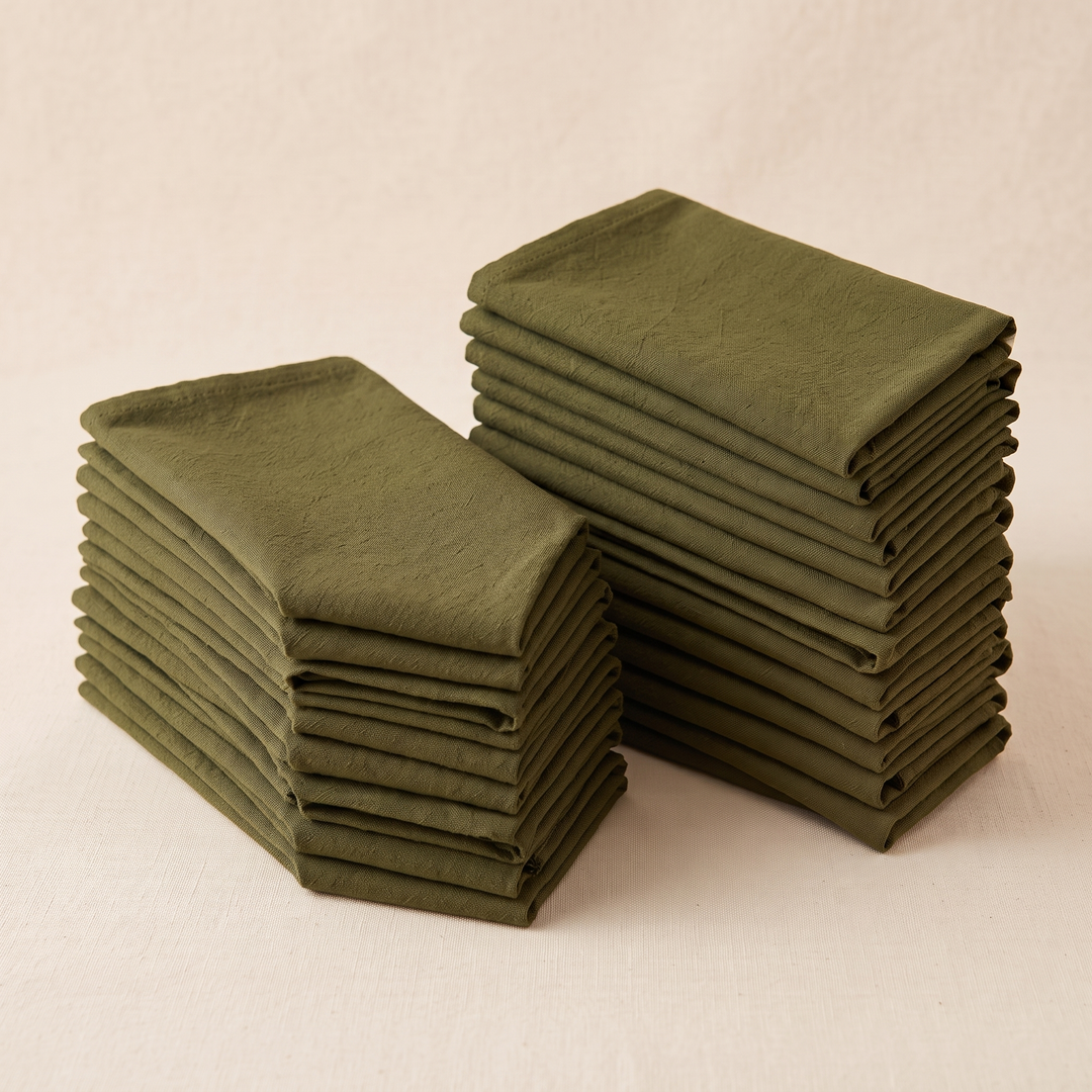 Cotton Cloth Napkins – Set of 24 in Olive Green – two neat stacks of folded napkins at an angle on cream