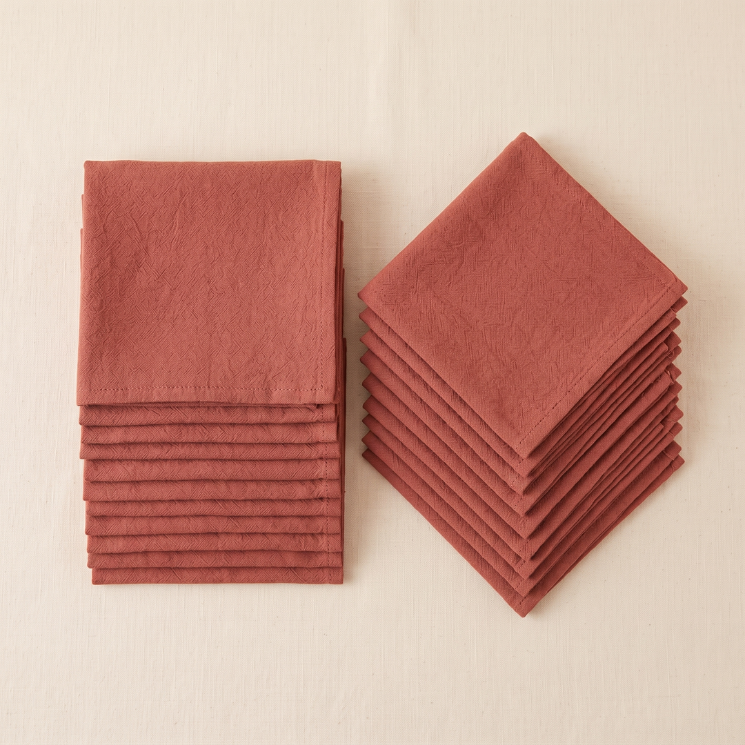 Cotton Cloth Napkins – Set of 24 in Rust – one stack set square beside another turned diagonally, seen from above