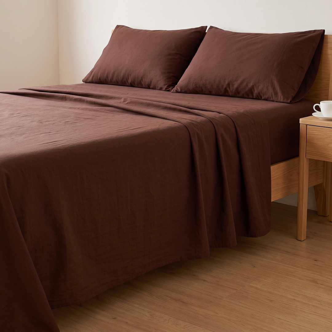 Cotton Flat Sheet Set – Percale, with 2 Pillowcases in Dark Brown – made bed beside a wooden nightstand holding a teacup