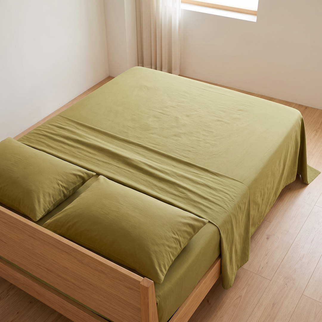 Cotton Flat Sheet Set – Percale, with 2 Pillowcases in Moss Green – high angle showing the top sheet folded back beneath two pillows