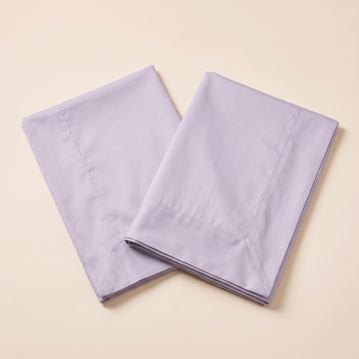 Cotton Sateen Pillowcases – Set of 2 in Lavender – pair angled in a v shape on pale peach surface