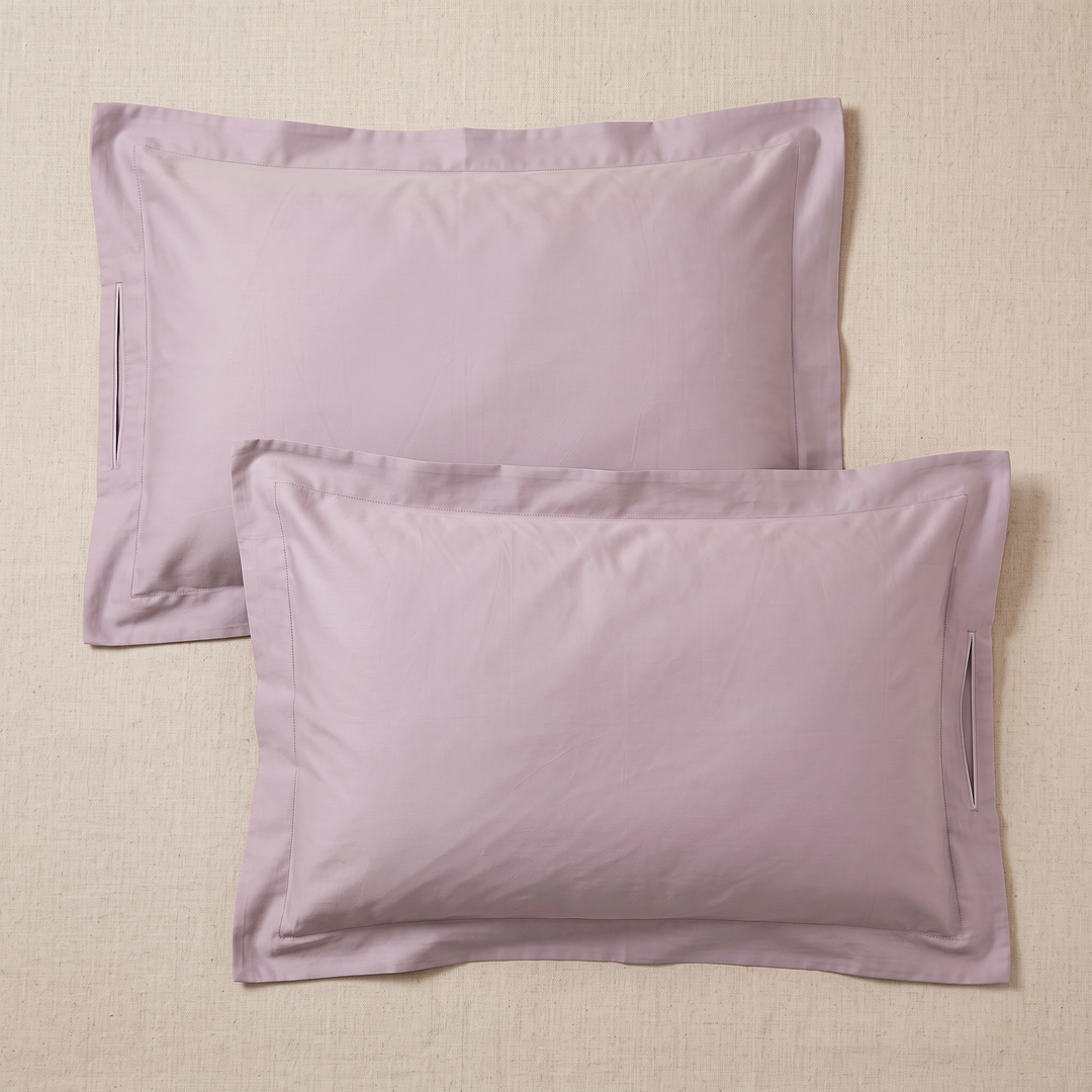 Cotton Sateen Pillowcases – Set of 2 in Mauve – unfolded pillowcases overlapping, showing side slit openings, on woven surface